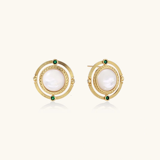 Circular gold stud earrings with iridescent mother-of-pearl center and green zirconia accents on cream background.