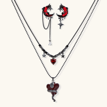 Gothic jewelry set with asymmetrical black metal earrings featuring red crescent moons, stars, and layered necklaces with heart pendants