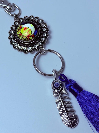 Sonne & Böser Blick Feder-Taschenanhänger: Boho-Handtaschen-Schlüsselanhänger mit violetter Quaste